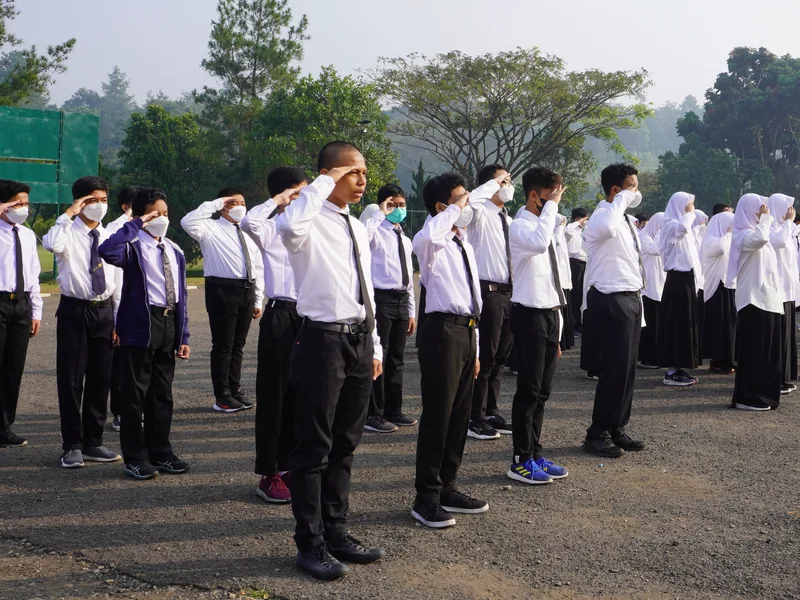Murid SMP memberi hormat dalam apel pagi di lapangan