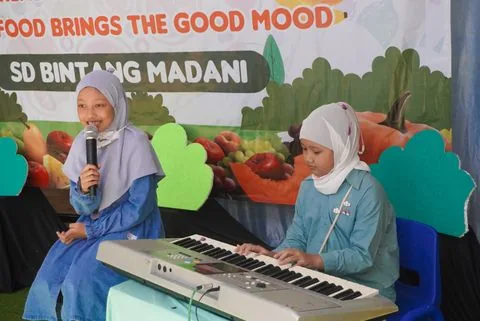 Dua murid SD mengiringi acara sekolah dengan keyboard
