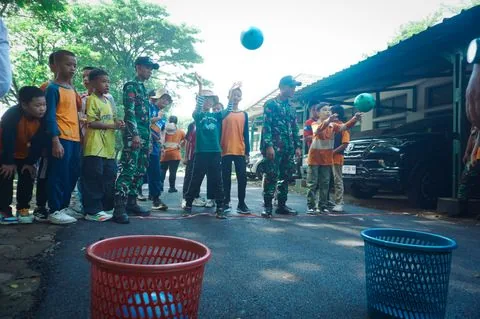 Murid SD mengikuti permainan kelompok di lapangan