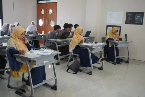 Murid SMA bekerja di laboratorium komputer