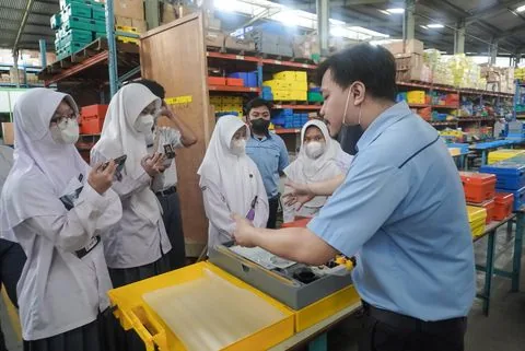 Murid SMA berdiskusi dengan pembimbing lapangan di pabrik