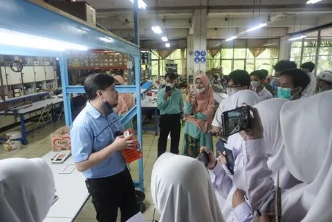 Murid SMA mengamati proses kerja mesin di pabrik mitra