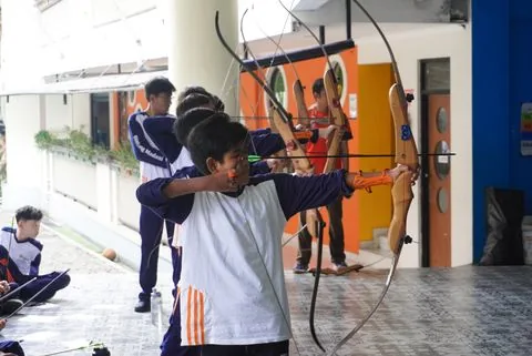 Murid SMP berlatih memanah di halaman sekolah