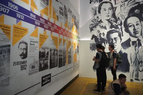 Murid SMP membaca lini masa sejarah pada dinding pameran