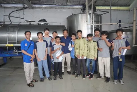 Murid SMP mengamati mesin produksi saat kunjungan industri