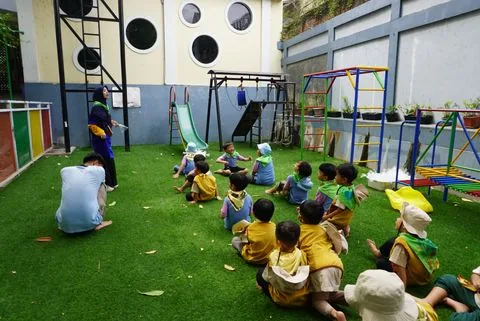 Murid TK berkumpul bersama guru di halaman sekolah