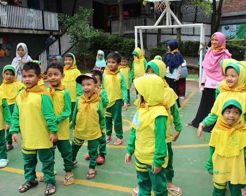 Murid TK berkumpul di halaman rumput sintetis sekolah