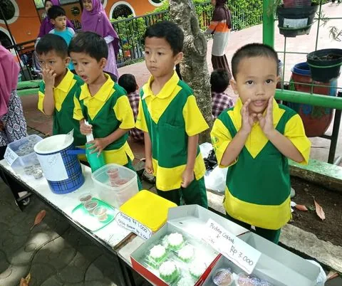 Murid TK mengikuti kegiatan praktik di meja bersama guru