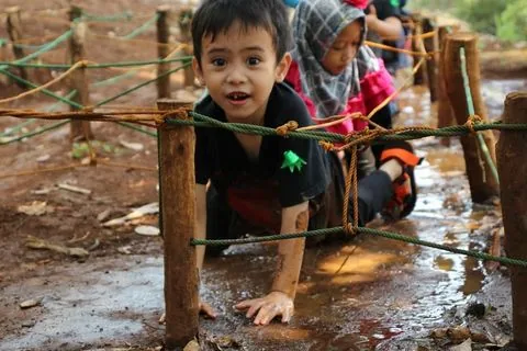 Murid TK merangkak melewati lintasan halang rintang