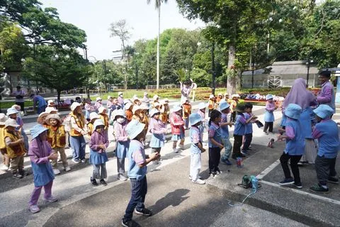 Rombongan murid TK berjalan beriringan saat kunjungan belajar